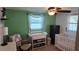 Bedroom with green walls, a crib, changing table, and a comfortable armchair at 2035 Erin Dr, Holiday, FL 34690