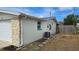 Exterior side view of house featuring white paint with stone veneer and a well manicured yard at 2035 Erin Dr, Holiday, FL 34690