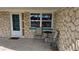 Close up of the entry door and an outdoor seating area on the covered front porch at 2035 Erin Dr, Holiday, FL 34690