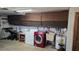 Garage featuring a red washer and dryer set, a utility sink, and abundant overhead storage cabinets at 2035 Erin Dr, Holiday, FL 34690