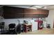 Garage interior with a laundry area featuring a red washer/dryer set and overhead storage cabinets at 2035 Erin Dr, Holiday, FL 34690