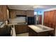 Traditional kitchen showcasing wood cabinetry, a center island with tile accents, and stainless steel appliances at 2035 Erin Dr, Holiday, FL 34690