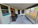 Relax in the screened porch with comfortable seating and backyard access at 2035 Erin Dr, Holiday, FL 34690