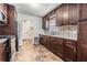 Well-lit kitchen features dark wood cabinets, tile backsplash, and stainless steel appliances at 2111 W Grace St, Tampa, FL 33607