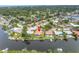 An aerial view of a beautiful waterfront home with a pool, dock, and lush landscaping at 2146 Egret Drive, Clearwater, FL 33764