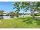 Canal view with a healthy manicured lawn and mature shade trees at 2146 Egret Drive, Clearwater, FL 33764