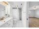 Bright bathroom features a walk-in shower, white cabinets, and gold fixtures at 2146 Egret Drive, Clearwater, FL 33764