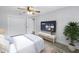Modern bedroom with gray wood floors, ceiling fan, and flat-screen TV at 2146 Egret Drive, Clearwater, FL 33764