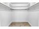 A minimalist walk-in closet with white shelving and wooden floors at 2146 Egret Drive, Clearwater, FL 33764