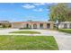 Charming home with a red tile roof, lush green lawn, and an inviting arched entryway at 2146 Egret Drive, Clearwater, FL 33764