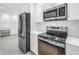 Modern kitchen with stainless steel appliances, ample white cabinetry, and sleek countertops at 2146 Egret Drive, Clearwater, FL 33764