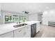 Bright, white kitchen featuring a large island with stainless steel appliances and views of the pool at 2146 Egret Drive, Clearwater, FL 33764