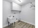 Bright laundry room featuring a utility sink and storage cabinets at 2146 Egret Drive, Clearwater, FL 33764