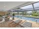 A covered patio with wicker furniture overlooks the gorgeous pool and waterfront views at 2146 Egret Drive, Clearwater, FL 33764