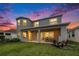 Large backyard featuring a covered patio, a lush lawn, and tasteful patio furnishings at 2693 Leafwing Ct, Palm Harbor, FL 34683