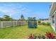 Landscaped backyard with green lawn, pergola, and trampoline at 2693 Leafwing Ct, Palm Harbor, FL 34683
