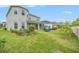 Spacious backyard with a covered patio, lush green lawn, and mature landscaping at 2693 Leafwing Ct, Palm Harbor, FL 34683