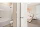 Bright bathroom featuring a shower-tub combo with white tiling and a glimpse into an adjacent bedroom at 2693 Leafwing Ct, Palm Harbor, FL 34683