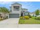 Charming two-story home with a balcony, a well-manicured lawn, and vibrant landscaping at 2693 Leafwing Ct, Palm Harbor, FL 34683
