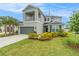 Charming two-story home with a balcony, a well-manicured lawn, and vibrant landscaping at 2693 Leafwing Ct, Palm Harbor, FL 34683