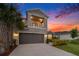 Inviting two-story home with a balcony, attached two-car garage, and lush front yard landscaping at 2693 Leafwing Ct, Palm Harbor, FL 34683