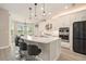 Kitchen boasts a large island, stainless appliances, and sleek white cabinetry at 2693 Leafwing Ct, Palm Harbor, FL 34683