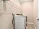 Efficient laundry room with modern washer and dryer, complemented by storage and shelving at 2693 Leafwing Ct, Palm Harbor, FL 34683