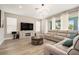 Stylish living room with a gray sectional couch, modern lighting, and large windows at 2693 Leafwing Ct, Palm Harbor, FL 34683