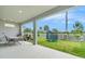 Covered patio features a dining table set and leads to the backyard with green grass and a trampoline at 2693 Leafwing Ct, Palm Harbor, FL 34683