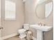 Tastefully designed powder room features a pedestal sink and round mirror at 2693 Leafwing Ct, Palm Harbor, FL 34683