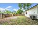 Wide view of a backyard with a wooden fence and a patch of grass beside a white home at 2921 N 18Th St, Tampa, FL 33605