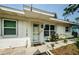 A close-up view of the house's entryway showing a storm door and well-tended landscaping at 306 Banana St, Tarpon Springs, FL 34689