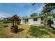 Quaint single-story home featuring a well maintained lawn, a decorative wishing well, and partial fencing at 306 Banana St, Tarpon Springs, FL 34689
