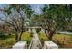 Charming single-story home with trees, sidewalk, and an American flag flying in the front yard at 306 Banana St, Tarpon Springs, FL 34689