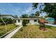 Inviting single-story home with a well-manicured lawn and a charming wishing well in the front yard at 306 Banana St, Tarpon Springs, FL 34689