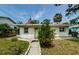 Cozy single-story home with a sidewalk, shuttered windows, an American flag, and a well-maintained lawn at 306 Banana St, Tarpon Springs, FL 34689