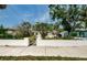 Charming single-story home with a white wall, green lawn, and a decorative wishing well at 306 Banana St, Tarpon Springs, FL 34689