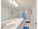 Bathroom featuring double sinks, a large mirror, and a walk-in shower at 3072 Inlet Breeze Way, Holiday, FL 34691