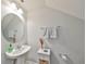 Powder room with pedestal sink, round mirror, and neutral wall color, creating a clean and functional space at 3072 Inlet Breeze Way, Holiday, FL 34691