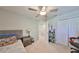 Bedroom with bed, nightstand, and open closet featuring an open door and ceiling fan at 3072 Inlet Breeze Way, Holiday, FL 34691