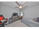 Bedroom with ceiling fan, window, gaming chair, and bed with grey comforter at 3072 Inlet Breeze Way, Holiday, FL 34691