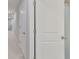 Hallway leading to bathroom, featuring carpeted floor and white doors at 3072 Inlet Breeze Way, Holiday, FL 34691