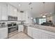 Bright kitchen featuring white cabinets, granite countertops, and stainless steel appliances at 3072 Inlet Breeze Way, Holiday, FL 34691