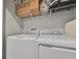 Laundry room featuring a modern, white washer and dryer, with storage shelves above at 3072 Inlet Breeze Way, Holiday, FL 34691
