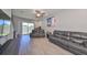 Spacious living room with hardwood floors, comfortable gray sofas, and sliding glass doors to a bright outdoor area at 3072 Inlet Breeze Way, Holiday, FL 34691