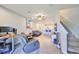Open-concept living room with ceiling fan, neutral walls, and staircase leading to the upper level at 3072 Inlet Breeze Way, Holiday, FL 34691