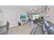 Comfortable living room featuring hardwood floors, TV, and ceiling fan, complemented by natural light and views at 3072 Inlet Breeze Way, Holiday, FL 34691