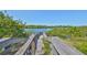 Scenic wooden walkway through lush greenery with serene water views under a clear blue sky at 3072 Inlet Breeze Way, Holiday, FL 34691