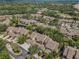 Expansive aerial view of a community with mature trees, manicured lawns, and a pond at 3079 Landmark Blvd # 1608, Palm Harbor, FL 34684