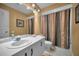 Bright bathroom featuring a white sink vanity and a shower with a decorative curtain at 3079 Landmark Blvd # 1608, Palm Harbor, FL 34684